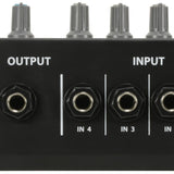 Close-up of the AVSL QTX MM41 4-Channel Mono Mini Microphone Mixer showing the 6.35mm output jack and IN 4, IN 3, IN 2 inputs below grey knobs.