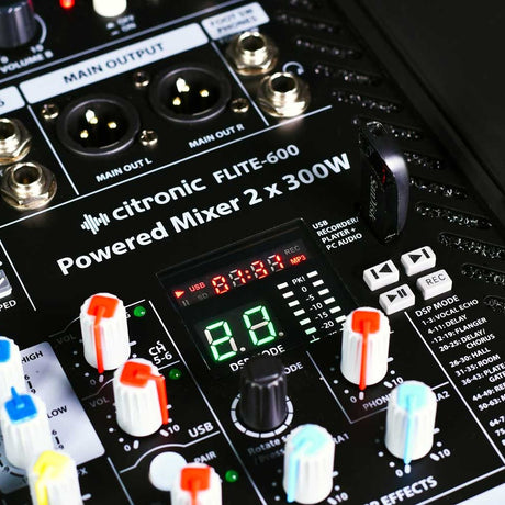 Close-up of Citronic FLITE-600 Powered Mixer showing main XLR outputs, DSP display, transport buttons, coloured faders and rotary controls on the black panel.