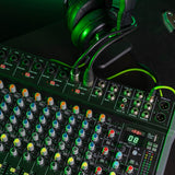 Citronic CMC-18 live mixing console with multiple mic/line inputs, EQ knobs, DSP display and USB port, shown with green-lit headphones resting above.