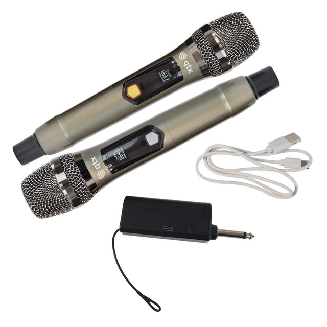 The QTX J-MIC Dual UHF Handheld Microphone System is displayed, featuring two wireless microphones with metal casings and mesh grilles. Included with the microphones are a USB cable and a compact black adapter with a 6.35mm plug, allowing for seamless licence-free operation.