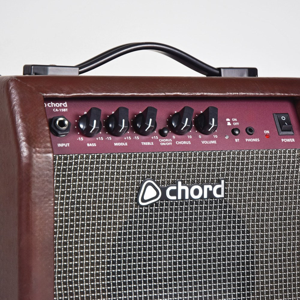 Close-up of the Chord CA-15BT 15W acoustic guitar amp control panel with input jack, bass, middle, treble, chorus and volume knobs, BT, phones and power switch.