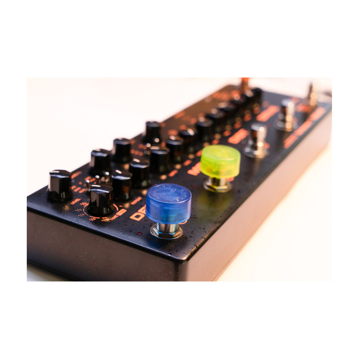 NU-X NST-1 blue and yellow plastic footswitch toppers fitted on a black effects pedal with orange labelling and control knobs.