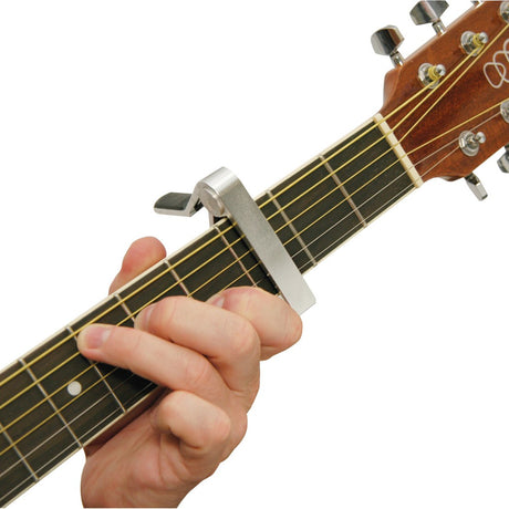 Chord SC2A silver spring-loaded capo clamped on a guitar fretboard, shown fitted while a hand forms a chord.