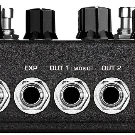 Close-up of the AVSL NU-X NDD-7 Tape Echo and Spring Reverb Pedal showing EXP, Out 1 Mono and Out 2 jack sockets below black control knobs.