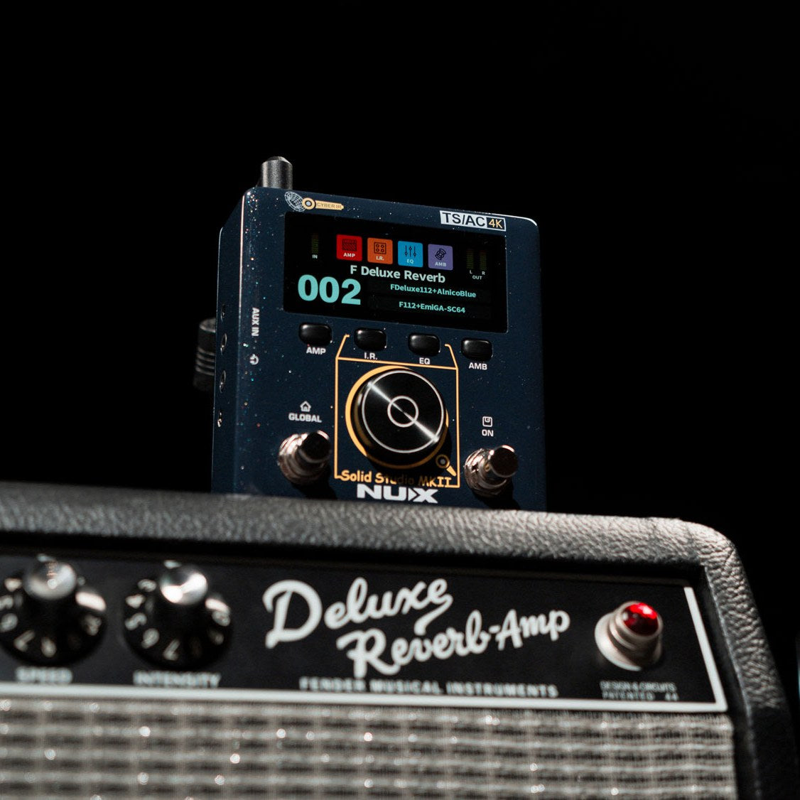 NU-X NSS-6 Solid Studio mkII amp and cab emulation pedal with colour display and data dial, shown on a Fender Deluxe Reverb amp against black.