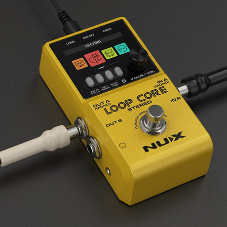 NU-X Loop Core Stereo looper pedal in yellow with colour LCD showing REC, Dub and Stop icons, rotary knob, four buttons, and cables connected.