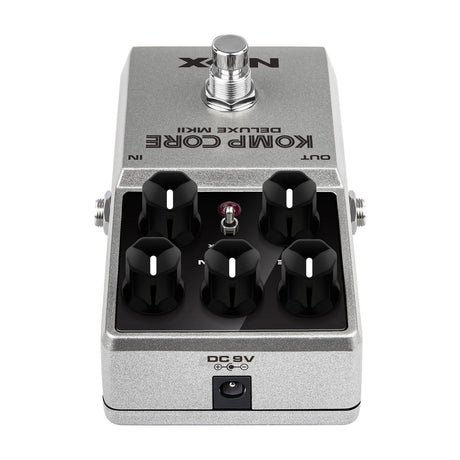 NU-X NCC-2 Komp Core Deluxe mkII compressor pedal shown end-on with five black knobs, toggle switch, silver casing and rear DC 9V power input.