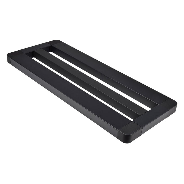 A black, rectangular metal frame described as the Chord Mini Pedal Board With Bag, featuring two open slots and a minimalist modern design. With non-slip feet and rounded corners, this board serves as a sturdy base or support, making it ideal for use as a table base or monitor stand.