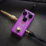 NU-X NDD-3 Edge Mini Delay Pedal in purple glitter finish with Mix, Repeat and Time knobs, mode button and footswitch, connected via jack leads.
