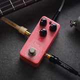 NU-X NSS-4 Pulse IR Loader guitar pedal in pink with Level and Space knobs, red LED and footswitch, connected via cables beside a guitar neck.