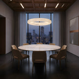A modern dining room with a round marble table, eight beige chairs, the Aurexis LED Large Floating Ring Alabaster Suspension Light in soft white above, floor-to-ceiling windows with city views at dusk, and abstract art on the wall.