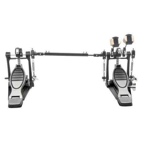 The Chord KPB22 Double Kick Drum Pedal Set consists of sleek black and silver chain-drive pedals linked by a connecting bar. These pedals boast textured footplates and dual beater holders with felt beaters installed above them, making this setup ideal for expertly playing bass drums.