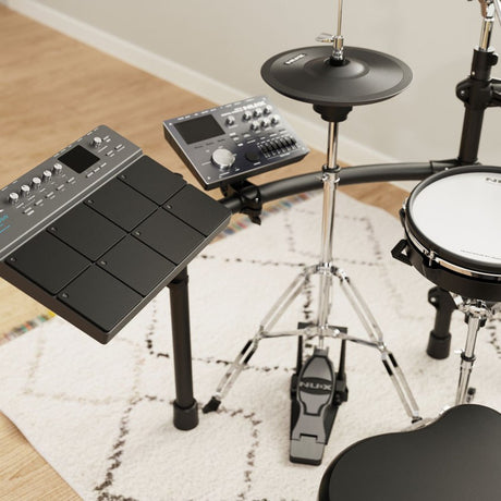 NU-X DP-2000 digital percussion pad with 8 black touch zones and control panel, mounted on a stand beside a hi-hat cymbal and snare on a rug.
