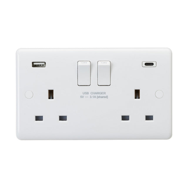 The 13A 2 Gang DP Switched Socket with Dual USB (Rounded Edge) is a white electrical wall socket made from durable thermoset resin and includes two USB ports—USB-A and USB-C. Each socket features a switch control positioned above it, with "USB CHARGER 5V 3.1A [shared]" labeled below. It combines anti-microbial properties with modern functionality to enhance safety.