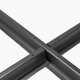 Close-up of the Steel Parasol Cross Base in matte black steel, showing the X-shaped crossbar joint with visible screw fixings on a plain white background.