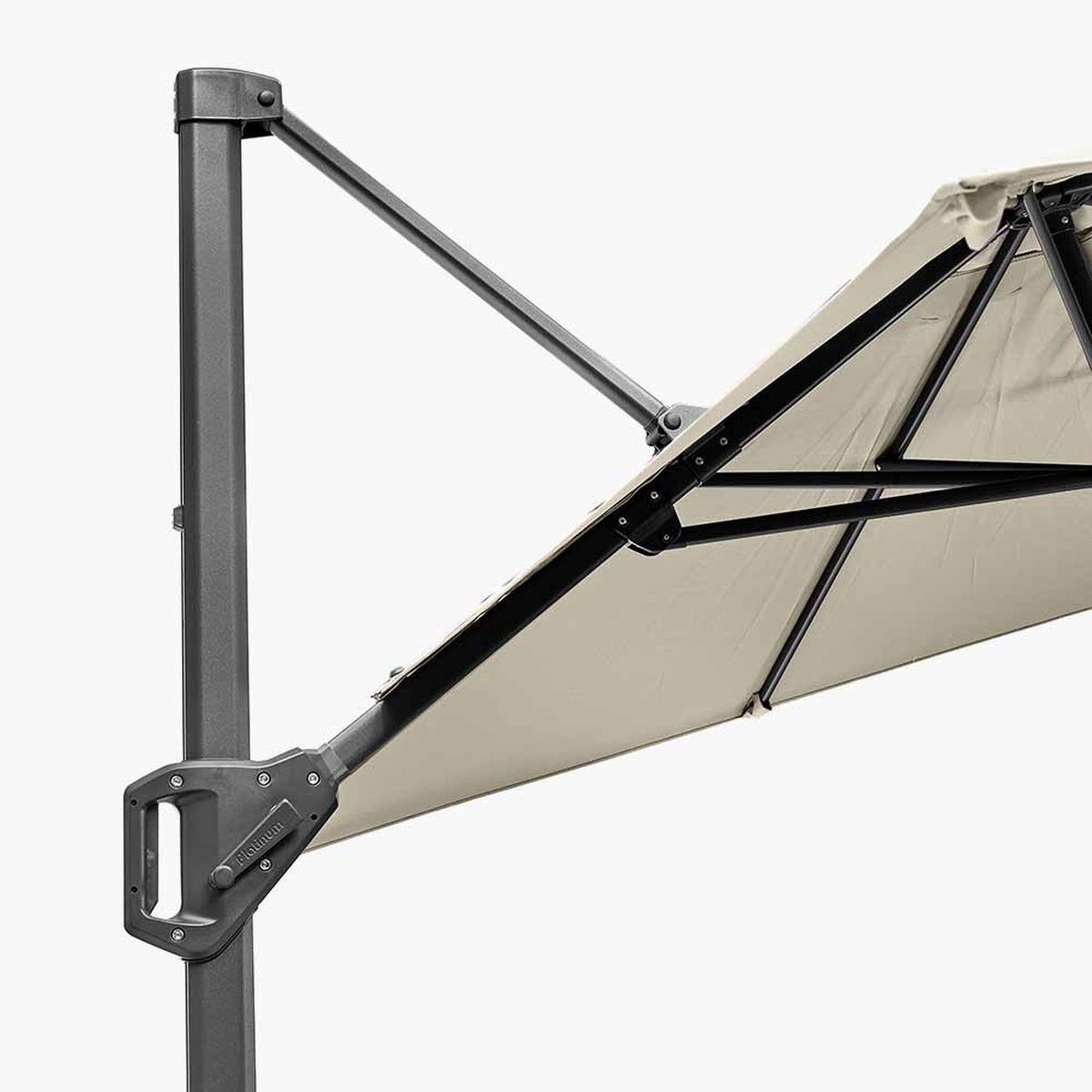 Close-up of the Voyager T1 X cantilever parasol in champagne, showing the dark grey aluminium pole, angled support arm, and canopy ribs against a plain background.
