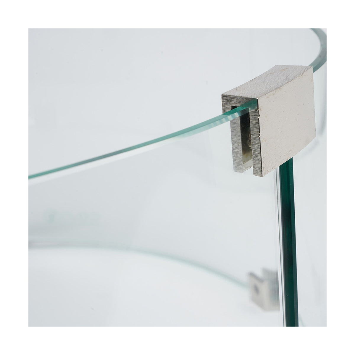 Close-up of the Cosiglass Large Fire Pit glass surround showing a curved tempered glass panel secured by a brushed metal bracket, set against a plain white background.