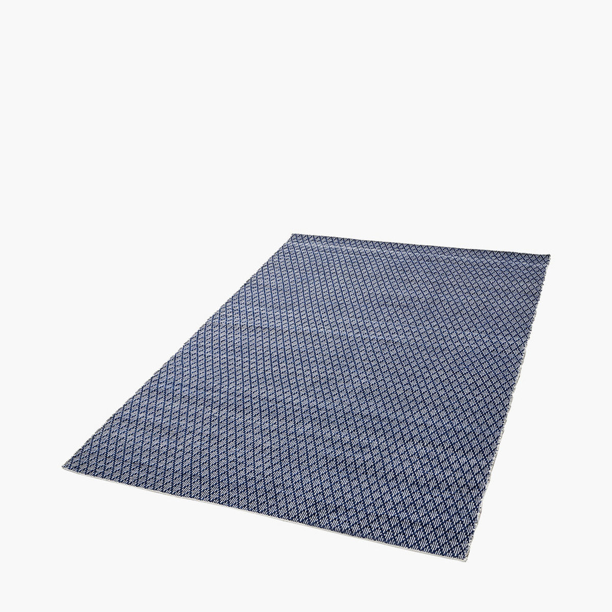Indoor outdoor rug, 230 x 160cm, with a denim blue and white ikat diamond pattern, shown at an angle on a plain light background.