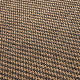 Close-up of an indoor outdoor rug in a woven houndstooth pattern, natural tan and slate grey polypropylene fibre, 230 x 160cm.