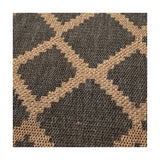 Close-up of an indoor-outdoor rug in slate grey and natural tan, showing a woven diamond trellis pattern in polypropylene fibre.
