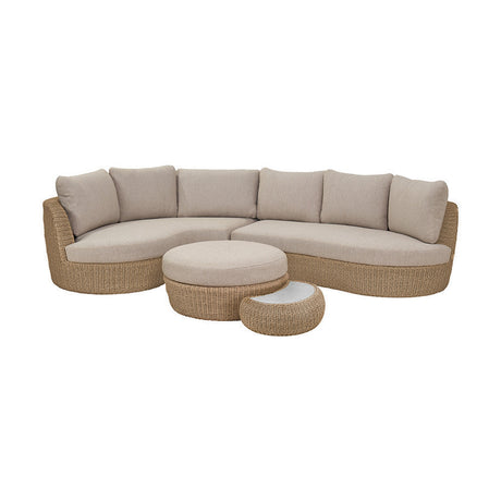 Kampala Outdoor Corner Set with curved woven rattan-effect sofa, beige cushions, round ottoman and side table, shown on a plain white background.