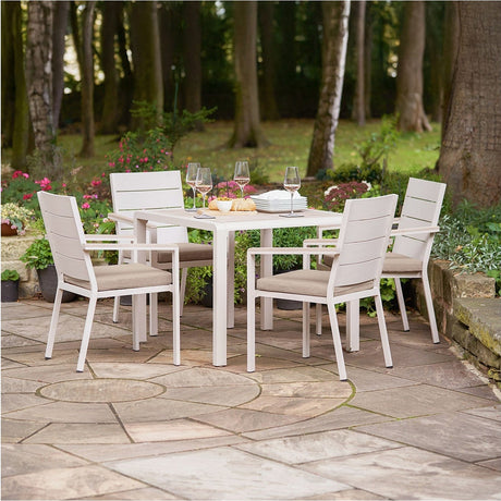 Aruba Outdoor 4 Seater Dining Set with square 91cm table and four cushioned armchairs, in beige aluminium and fabric, set on a garden patio surrounded by greenery.