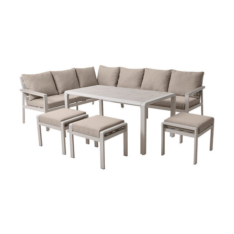Aruba Outdoor Corner Seating Set with white aluminium frame, beige cushions, dining table, and four matching stools on a plain white background.