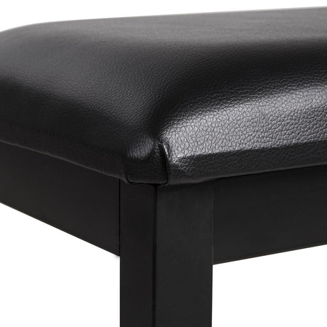 Close-up of the AVSL NU-X Piano Bench corner, showing the padded black upholstered seat and matt black metal frame legs.