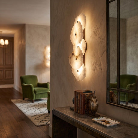 Frammenta LED 5 Light Fragment Alabaster Wall Light with brass fixings, glowing on a hallway wall beside a mirror and console table.