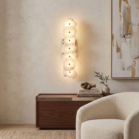 Frammenta LED 7 Light Fragment Alabaster Wall Light in brass, illuminated with a staggered column of raw-edged alabaster slabs, shown mounted above a walnut sideboard in a living room.