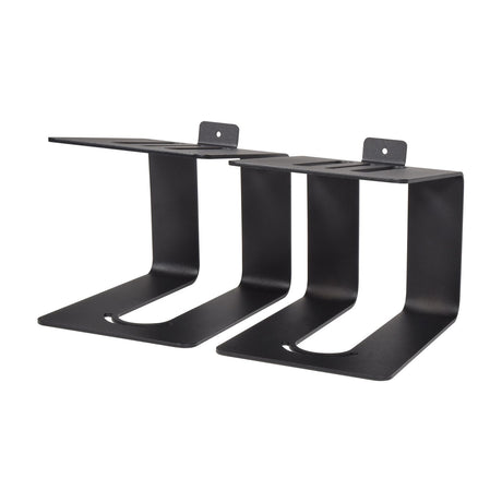 Pair of QTX matte black metal desktop speaker stands with curved bases and wall-mount tabs, shown on a plain white background.