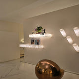 Kate LED Alabaster Wall Shelf Light Small in soft white, illuminated rectangular alabaster ledges mounted on a wall, styled with decor in a home hallway setting.