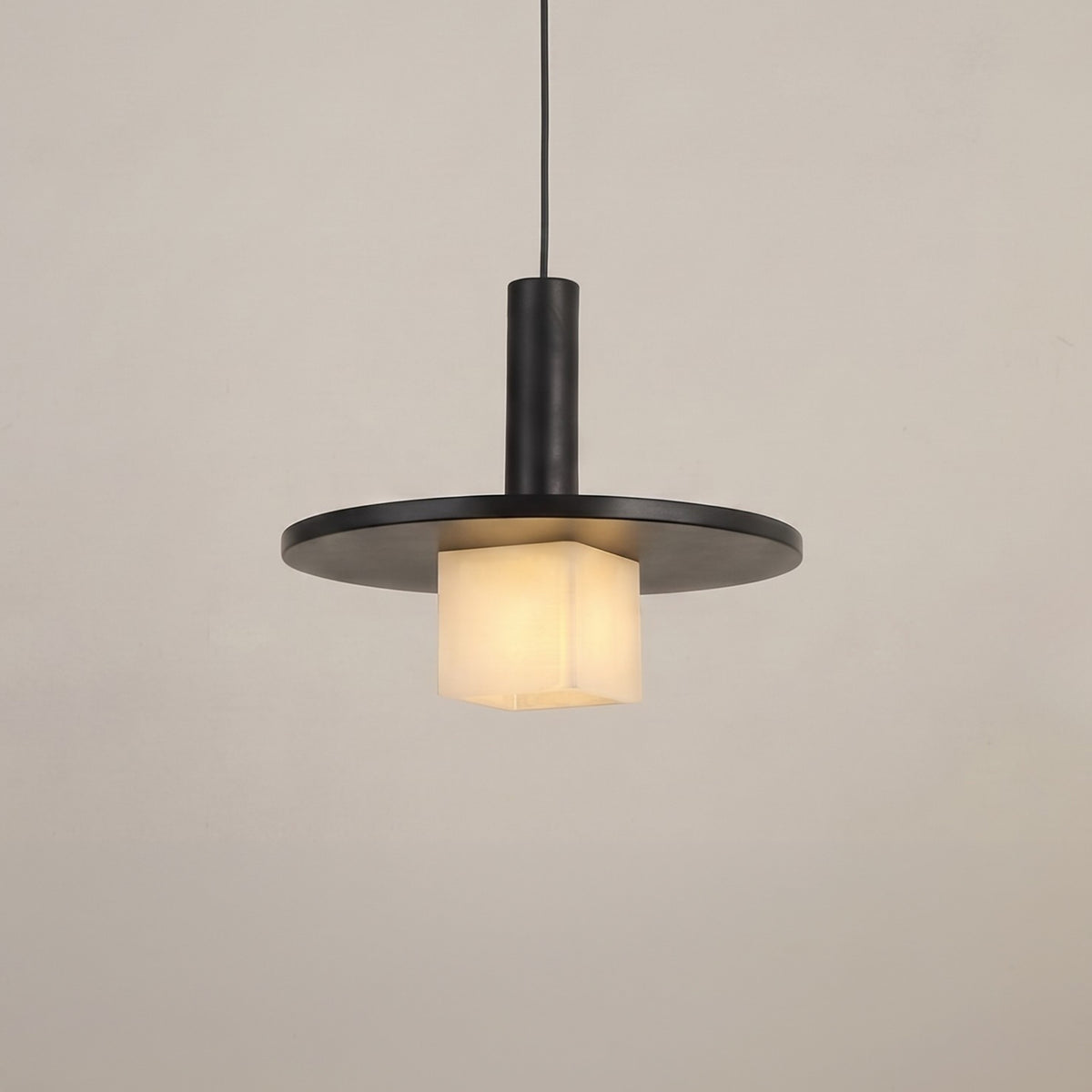 Norevia Cube Alabaster Pendant Light in matte black, featuring a wide disc canopy, slim stem, and glowing alabaster cube shade, shown against a plain light background.