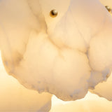 Close-up of layered, translucent alabaster with soft, warm lighting and two small brass fasteners shows the elegant textures and cloudy patterns of the Solvane LED Small Petal Alabaster Chandelier in Soft White & Brass.