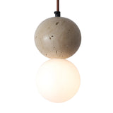 The Belvoro 1 Light Dual Sphere Travertine Single Pendant Light in light beige features a natural travertine stone sphere above a glowing white glass sphere, both suspended by a brown cord against a white background.