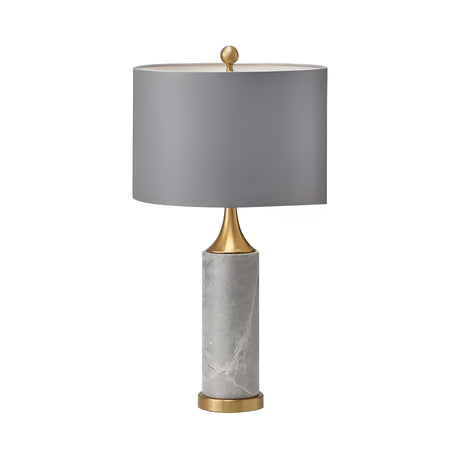 The Valoma 1 Light Sculpted Marble Table Lamp in brass and grey features gold accents and a round gray lampshade, displayed against a white background.