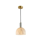 The Belvix 1 Light Small Dome Alabaster Single Pendant Light in soft white and brushed brass features a translucent dome-shaped shade and black cord, softly illuminated against a white background.