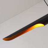 The Stealth 2 Light Linear Suspension - Brass & Black features a sleek, modern design with an elongated, curved form and warm glow, suspended from the ceiling against a white backdrop for a sophisticated look.