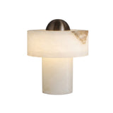 Cupolino Dome Alabaster Table Lamp with a cylindrical alabaster base, wide alabaster drum shade, and brushed brass dome top, lit warmly against a plain white background.