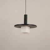 Norevia Cube Alabaster Pendant Light in matte black, featuring a wide flat disc canopy, slim cylindrical stem, and square alabaster glass shade, shown against a plain light background.