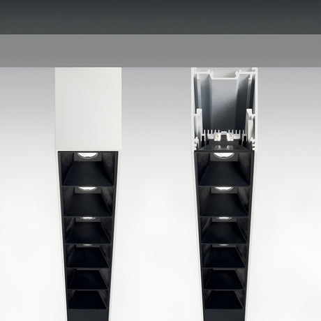 Close-up view of streamlined, contemporary lighting interiors. One Sparx Linear LED Suspension Light 30W 3000K - White, 1205mm is shown with its cover, while another is open to display the internal structure of this energy-efficient model. The lights feature a linear, minimalist design set against a plain background.