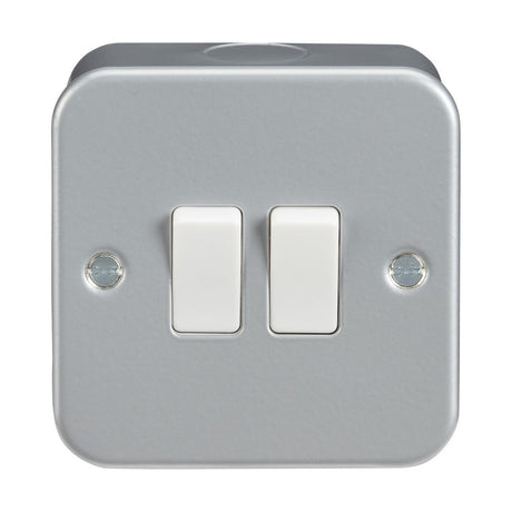 The Metal Clad 10AX 2 Gang 2-Way Switch offers a resilient powder-coated surface with gray plastic construction, featuring two white toggle switches and visible screw holes. Its design includes rounded edges and a smooth finish for an optimal blend of style and functionality.