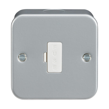 The Metal Clad 13A Fused Spur Unit features a square design with rounded corners, crafted from premium-grade steel. At the center of the metallic surface is a switch labeled "FUSE" in raised letters, accompanied by two visible screws. The unit's overall aesthetic is straightforward and industrial, echoing the style of a sturdy metal-clad box.