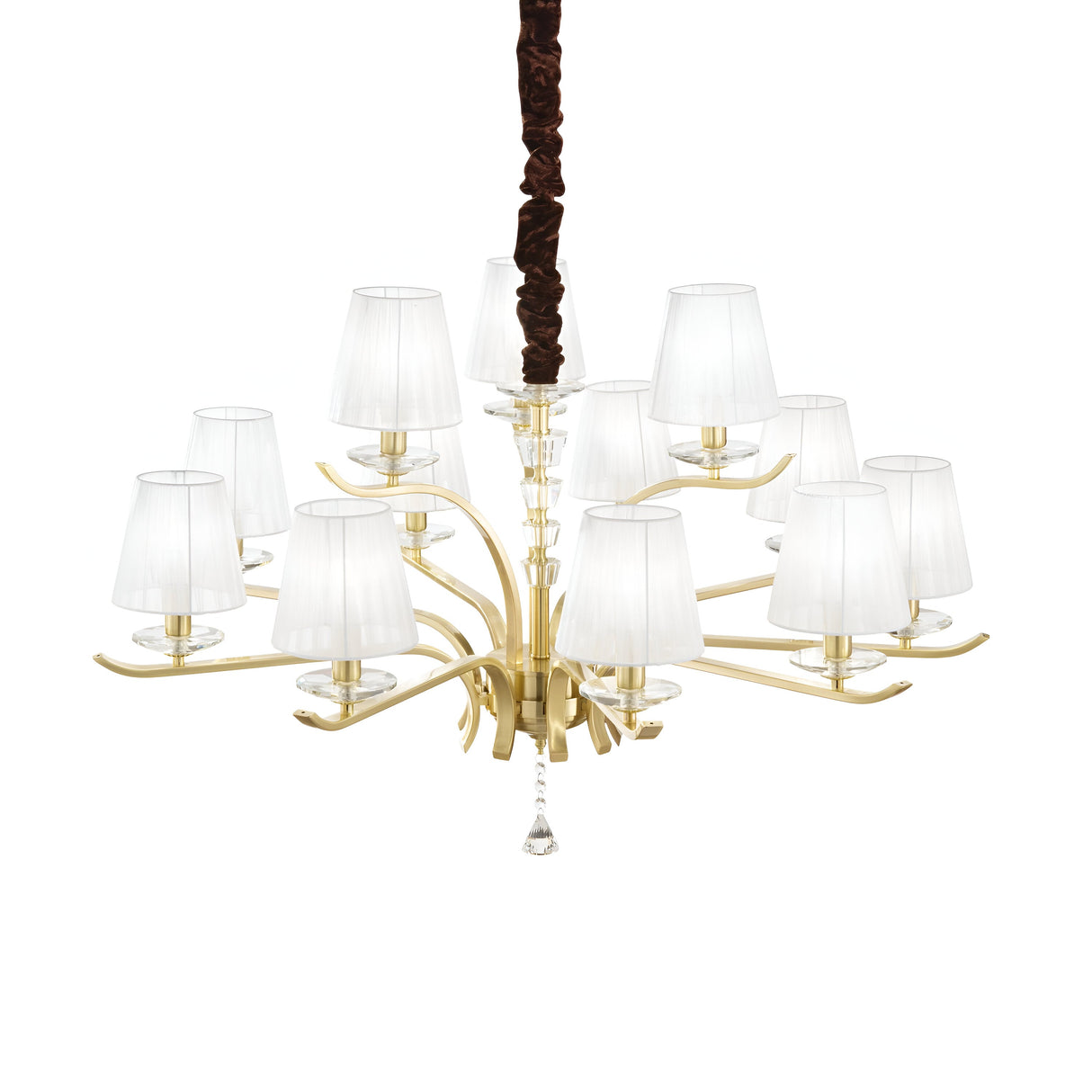 The Solum 12 Light Chandelier - Brass showcases a sophisticated design with its gold frame and twelve white lampshades. Its elegantly curved arms are adorned with crystal elements, enhancing its luxurious appeal. Suspended from a dark cord, this symmetrical chandelier stands out as an epitome of luxury lighting against a plain white background.