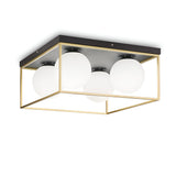 The Dawn 4 Light Flush - Brass features a modern design with white spherical bulbs encased in a sleek, square brass frame. This minimalist flush light is mounted on a black base for seamless ceiling integration, epitomizing contemporary elegance and style.