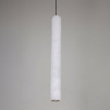 Zenvia LED Alabaster Single Pendant Light with a slim fluted white stone column, brushed brass ceiling cap, and black drop cable against a plain grey background.