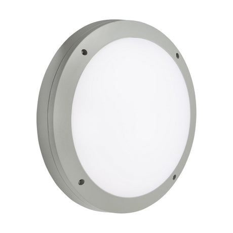The 18W Outdoor CCT LED Bulkhead with Daylight Sensor in Grey is a round, wall-mounted light fixture featuring a smooth grey-metal frame, a white impact-resistant polycarbonate diffuser, and three visible screws for easy mounting. Its sleek and modern design makes it suitable for both indoor and outdoor use. This IP65-rated LED bulkhead is perfect for diverse applications.