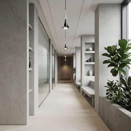A modern, minimalist hallway with neutral walls and floors, built-in shelves with vases, large potted plants, and the Droplet LED Pendant Light - White & Black illuminating the space as a glass wall runs along the left side.