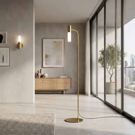 Minimalist living room featuring the Magari Floor Lamp - Gold, a wooden sideboard, modern wall art, a potted plant by large glass windows with city views. Neutral tones and sleek, contemporary decor complete the space.