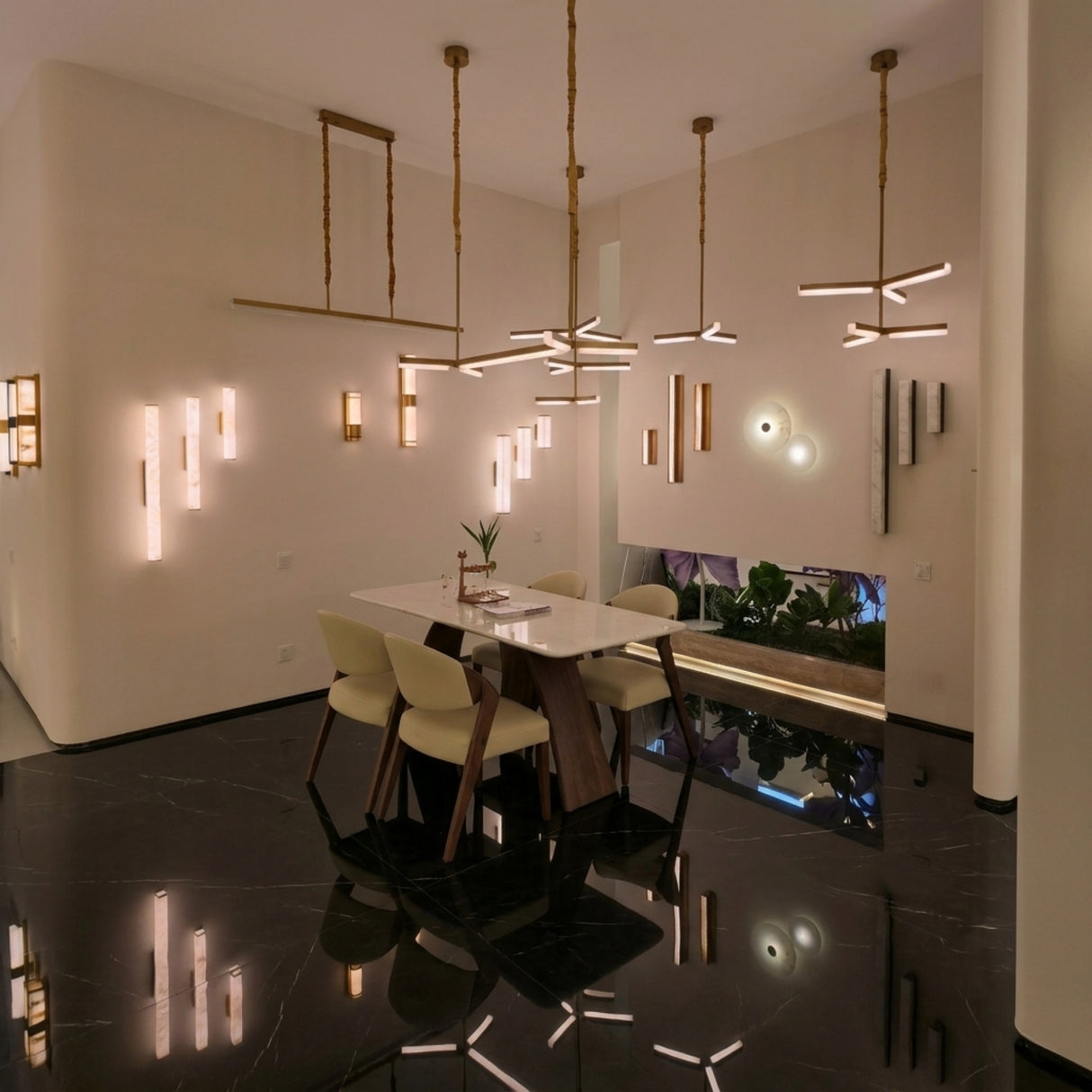 Elvaris LED Small Vertical Alabaster Wall Light in brushed brass, shown illuminated among multiple wall lights in a modern dining room with marble flooring.
